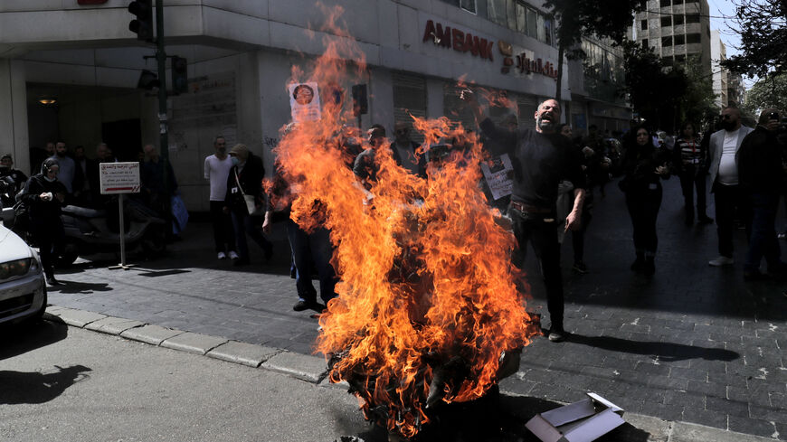 Lebanese protestors burn tyres outside a private bank during a demonstration by members of the banks depositors committee against monetary policies, on March 24, 2023. - Lebanon's economic meltdown, described by the World Bank as one of the worst in recent global history, has plunged most of the population into poverty according to the United Nations. (Photo by ANWAR AMRO / AFP) (Photo by ANWAR AMRO/AFP via Getty Images)