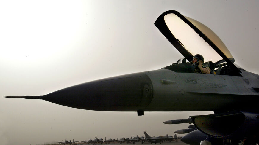 An F-16 pilot from an airbase in Saudi Arabia gets ready to disembark from his aircraft after he was diverted to Kuwait because of bad weather after his mission into Iraq March 26, 2003 as Operation Iraqi Freedom continues after a pause in the air campaign due to bad weather. (Photo by Paula Bronstein/Getty Images)