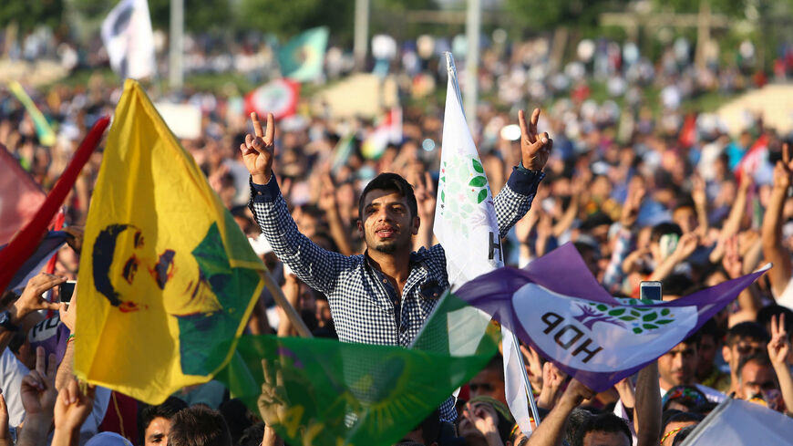 DIYARBAKIR, TURKEY - JUNE 8: Supporters of the Pro-Kurdish Peoples' Democratic Party (HDP) wave flags with a picture of the jailed Kurdish militant leader Abdullah Ocalan as they cheer during a gathering to celebrate their party's success in the parliamentary elections, on June 8, 2015 in Diyarbakir, Turkey. Turkey now faces the prospect of weeks of political unrest after the AK Party lost its parliamentary majority in polls over the weekend. (Photo by Burak Kara/Getty Images)
