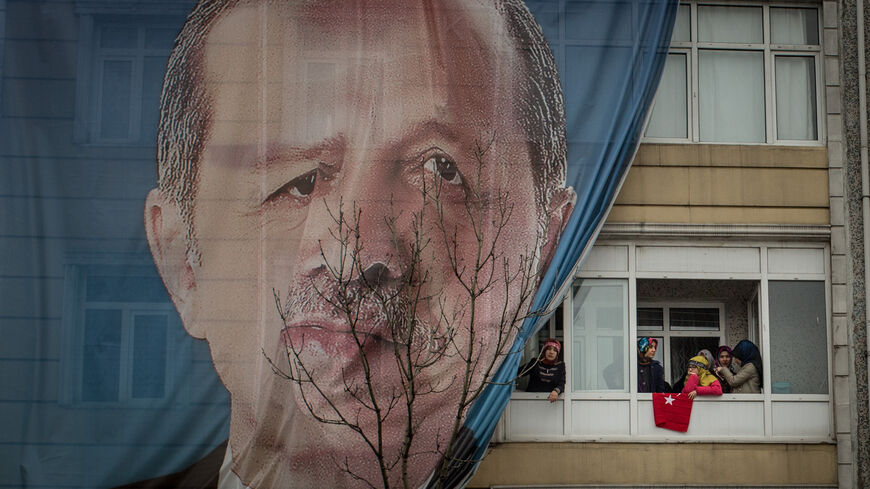 People watch on from a balcony displaying a large banner of Turkish President Recep Tayyip Erdogan outside a "Yes" (EVET) referendum campaign rally event attended by Turkish President Recep Tayyip Erdogan on March 11, 2017 in Istanbul, Turkey.(Photo by Chris McGrath/Getty Images)