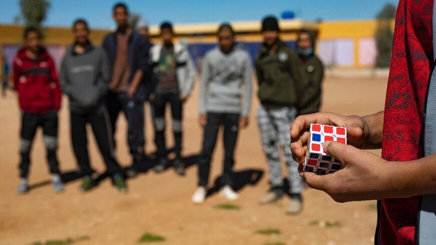 A child of a foreign Islamic State group (IS) fighter holds a Rubik's Cube in a playground at the Orkesh rehabilitation centre in northeastern Syria