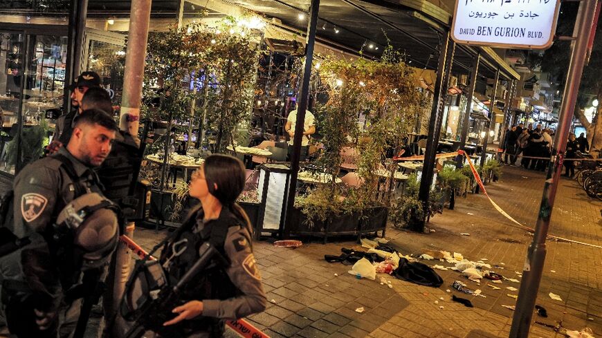 Israeli border guards stand outside the venue that was the scene of a shooting attack along Dizengoff Avenue in the centre of Tel Aviv 