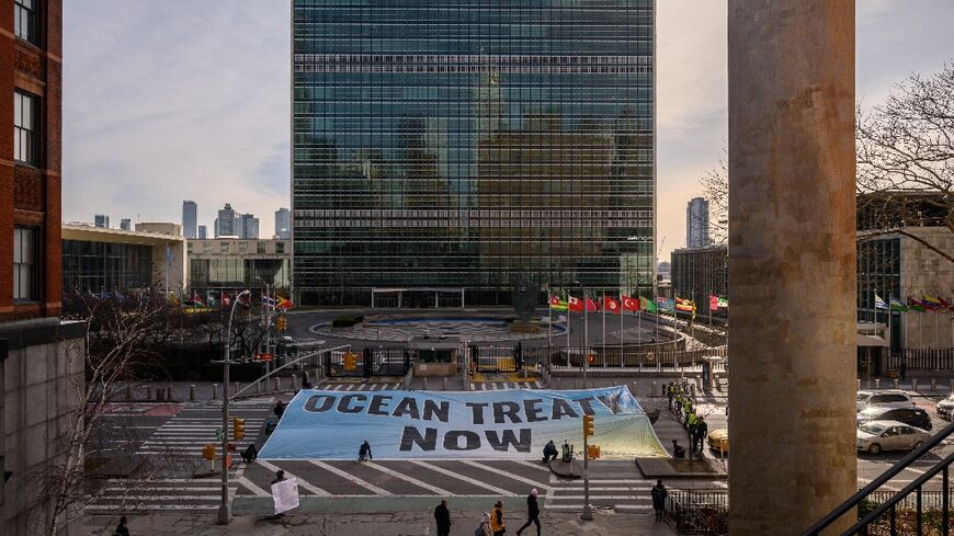 Activists from Greenpeace display a banner outside the United Nations headquarters during negotiations on a treaty to protect the high seas