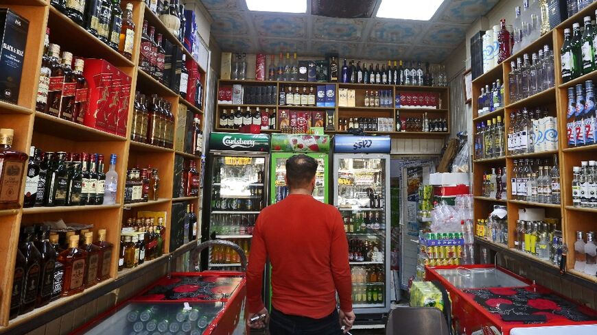 A customer surveys the drinks on offer in a Baghdad liquor store, days after a ban on the sale, import or production of alcohol took effect
