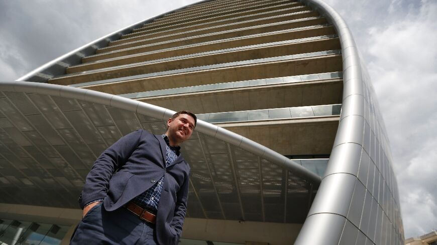 Russian IT specialist Dmitri Leonov poses next to 'The Oval', part of the transformed Limassol skyline