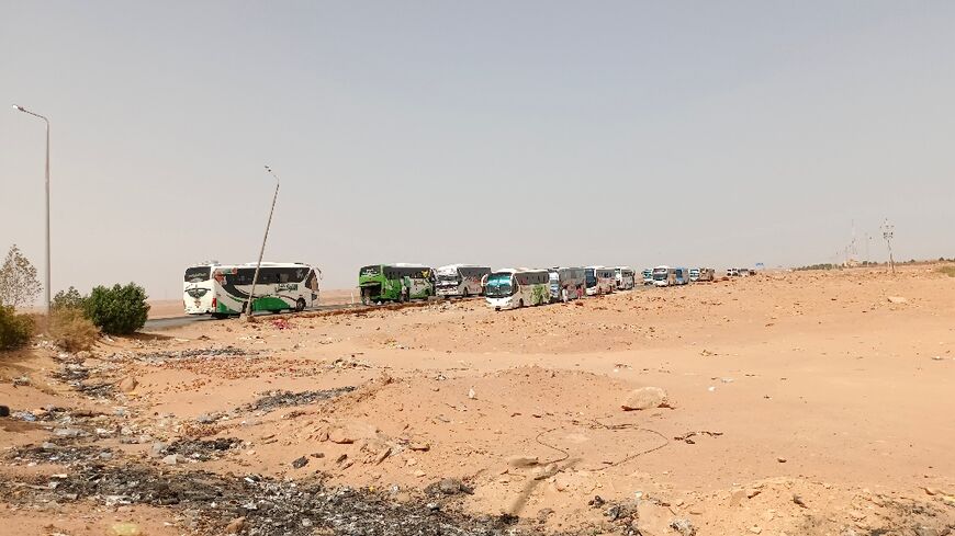 A bus convoy from war-torn Sudan arrives at the Wadi Karkar bus station near the Egyptian city of Aswan, on April 25, 2023