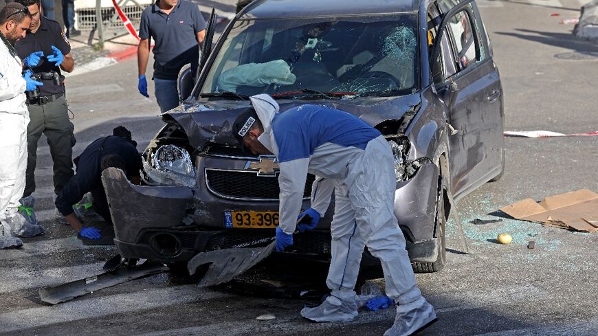 Israeli police and emergency personnel inspect a damaged vehicle following an incident in Jerusalem