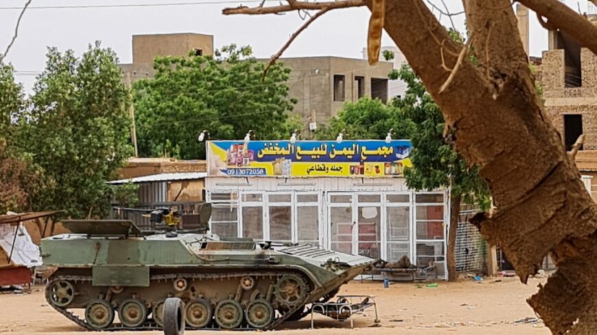 Sudanese Army soldiers rest beside an armoured vehicle at a checkpoint in Khartoum 