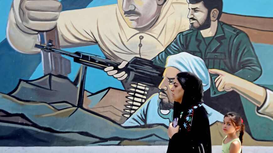 Pedestrians walk past a political mural at Palestine Square in the Iranian capital Tehran on September 7, 2019. - Iran said Saturday it has fired up advanced centrifuges to boost its enriched uranium stockpiles, in the latest scaling back of commitments under a crumbling 2015 nuclear deal. (Photo by ATTA KENARE / AFP) (Photo credit should read ATTA KENARE/AFP via Getty Images)