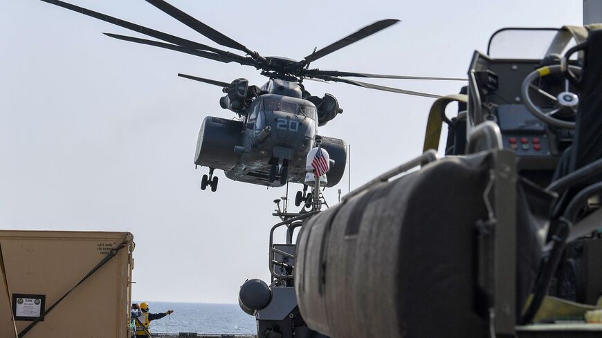 A US Black Hawk helicopter takes off from Britain's RFA Cardigan Bay landing ship in the Gulf waters off Bahrain stand next to a rigid-hull inflatable boat during the International Maritime Exercise (IMX), on November 5, 2019. - IMX is a joint military exercise involving assets and personnel from more than 50 partner nations and seven international organisations. The US has pushed for the creation of a US-led operation dubbed the International Maritime Security Construct to safeguard trade and the flow of o