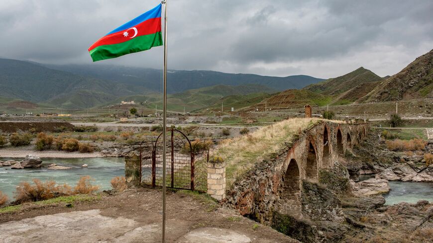 An Azerbaijani national flag flies next to the mediaeval Khudaferin bridge in Jebrayil district at the country's border with Iran - the territories recaptured from Armenian forces in fierce clashes over the disputed Nagorno-Karabakh region that were under Armenian separatists' control for nearly three decades, on December 9, 2020. (Photo by STRINGER / AFP) (Photo by STRINGER/AFP via Getty Images)