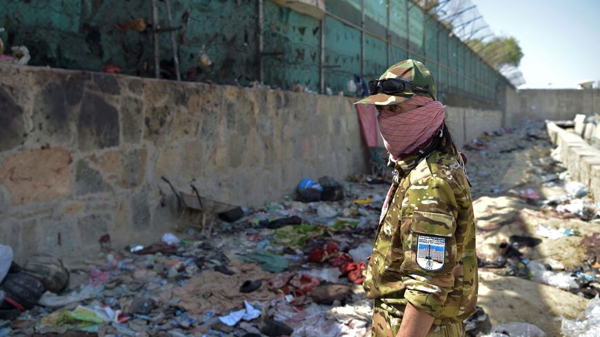 A Taliban fighter stands guard at the site of the August 26 twin suicide bombs, which killed scores of people including 13 US troops, at Kabul airport on August 27, 2021. (Photo by WAKIL KOHSAR / AFP) (Photo by WAKIL KOHSAR/AFP via Getty Images)