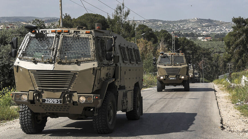 Israeli military vehicles drive during clashes between Palestinians and Israeli forces in the Palestinian refugee camp of Jenin in the occupied West Bank on April 9, 2022.