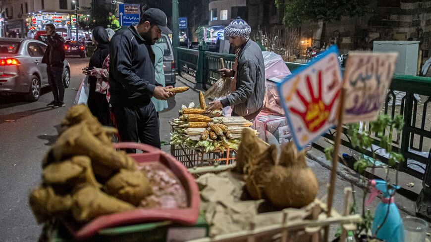 A pedlar sells roasted corn cobs by the medieval Sultan al-Ghuri Complex (built in 1505) in the Azhar district of Egypt's capital Cairo on January 16, 2023. (Photo by Khaled DESOUKI / AFP) (Photo by KHALED DESOUKI/AFP via Getty Images)