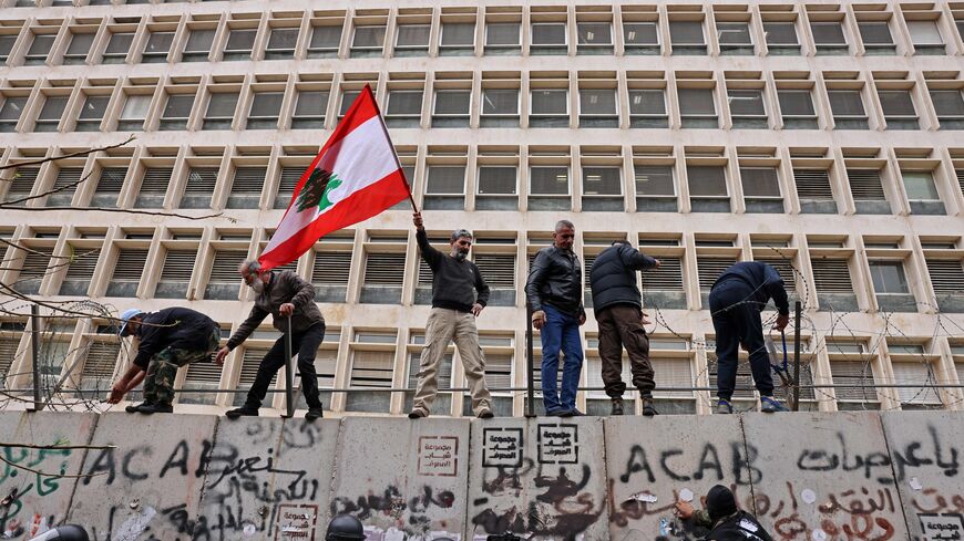 Retired servicemen remove razor wire barricade outside Lebanon's central bank during a demonstration demanding inflation-adjustments to their pensions, in Beirut on March 30, 2023. (Photo by JOSEPH EID / AFP) (Photo by JOSEPH EID/AFP via Getty Images)