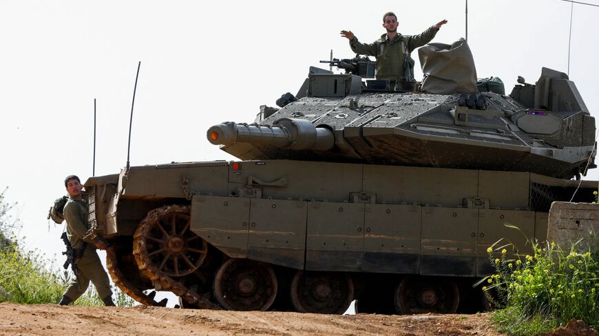 TOPSHOT - Israeli soldiers take up a position with a tank near Shtula, bordering Lebanon, on April 7, 2023. - Israel launched air strikes before dawn on April 7 in the Gaza Strip and Lebanon, saying it was targeting Palestinian militant group Hamas in retaliation for several dozen rockets fired at Israel from both territories. (Photo by Jalaa MAREY / AFP) (Photo by JALAA MAREY/AFP via Getty Images)