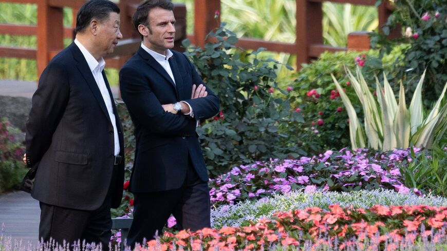 Chinese President Xi Jinping (L) and French President Emmanuel Macron (R) speak as they visit the garden of the residence of the Governor of Guangdong, on April 7, 2023, where Chinese President XI Jinping's father, XI Zhongxun lived. (Photo by Jacques WITT / POOL / AFP) (Photo by JACQUES WITT/POOL/AFP via Getty Images)