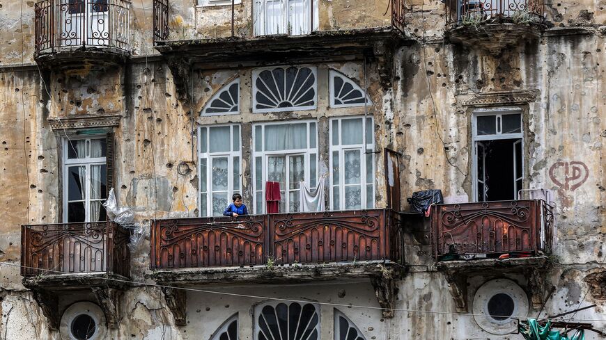 A boy stands in the balcony of a building ravaged by Lebanon's Civil War, in Beirut's Ras al-Nabeh district on April 13, 2023. - The Lebanese civil war broke out on April 13, 1975 and ended in 1990 with the Taef agreement. (Photo by ANWAR AMRO / AFP) (Photo by ANWAR AMRO/afp/AFP via Getty Images)