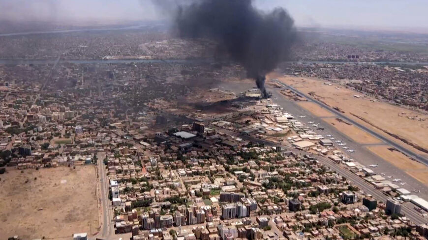 This image grab taken from AFPTV video footage on April 20, 2023, shows an aerial view of black smoke rising above the Khartoum International Airport amid ongoing battles between the forces of two rival generals. 