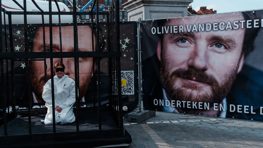 Belgian Manon Vandecasteele sits blindfolded in a cell during a protest action for her uncle Olivier Vandecasteele, who is imprisoned in Iran, on the Grand-Place in Tournai on April 22, 2023. - Belgium on April 18, 2023 said it had formally asked Iran to repatriate jailed aid worker Olivier Vandecasteele from Tehran, after a disputed prisoner exchange treaty entered into force. Iran arrested Vandecasteele, 42, in February 2022 and sentenced him to 40 years for spying, in a move condemned as "hostage diploma