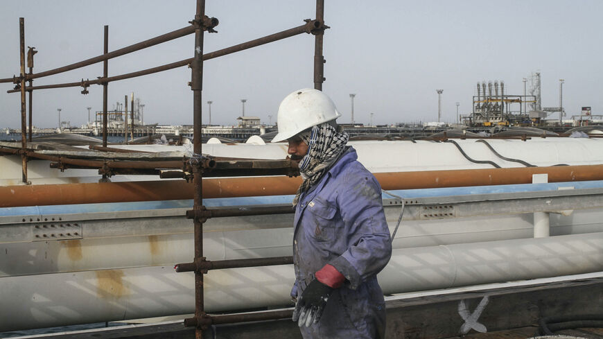 An Iranian man works at an oil facility in the Khark Island, on the shore of the Gulf, on February 23, 2016. - Iran's Oil Minister Bijan Namdar Zanganeh dismissed an output freeze deal between the world's top two producers Saudi Arabia and Russia as "a joke", the ISNA news agency reported. (Photo by AFP) (Photo by STR/AFP via Getty Images)