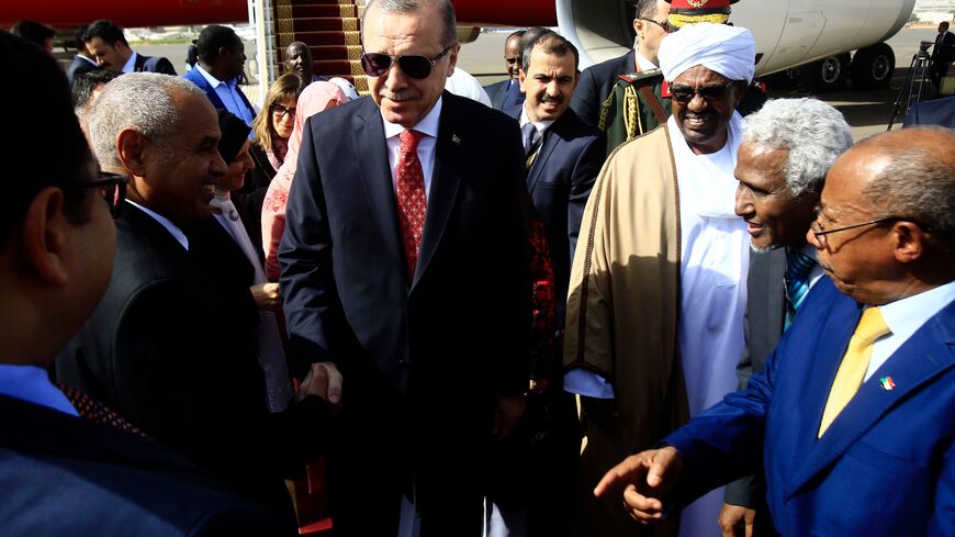 Turkish President Recep Tayyip Erdogan (C) is welcomed by his Sudanese counterpart Omar al-Bashir (2nd-L) and diplomats upon his arrival in Khartoum on December 24, 2017, for a two-day-official visit. / AFP PHOTO / ASHRAF SHAZLY (Photo credit should read ASHRAF SHAZLY/AFP via Getty Images)