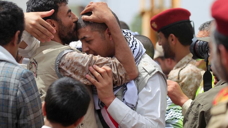 Yemeni Huthi rebel prisoners are welcomed during a ceremony upon their arrival at Sanaa airport on April 15, part of a prisoner exchange that will see nearly 900 detainees released