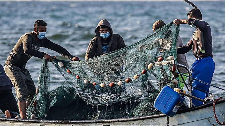 Palestinian fishermen in 2020 with fish caught in the Mediterranean Sea off Rafah in the southern Gaza Strip 