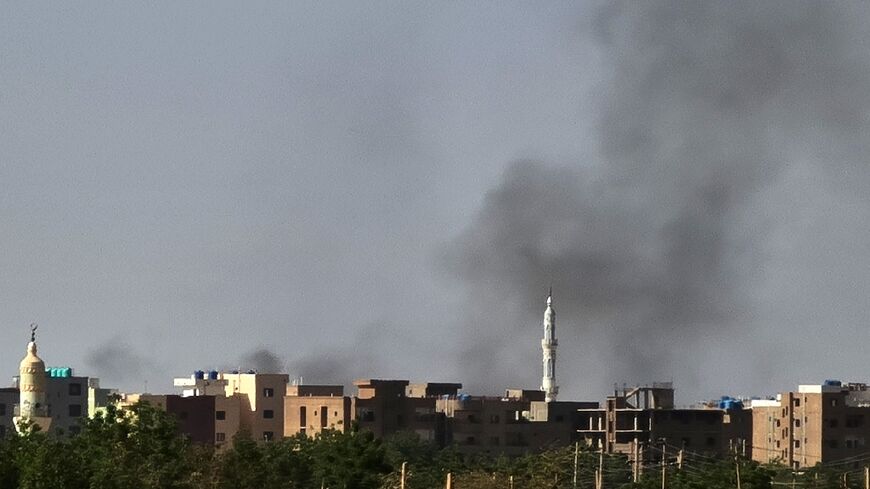 Smoke rises behind a mosque in the Sudanese capital Khartoum on May 7, 2023, as fighting continues