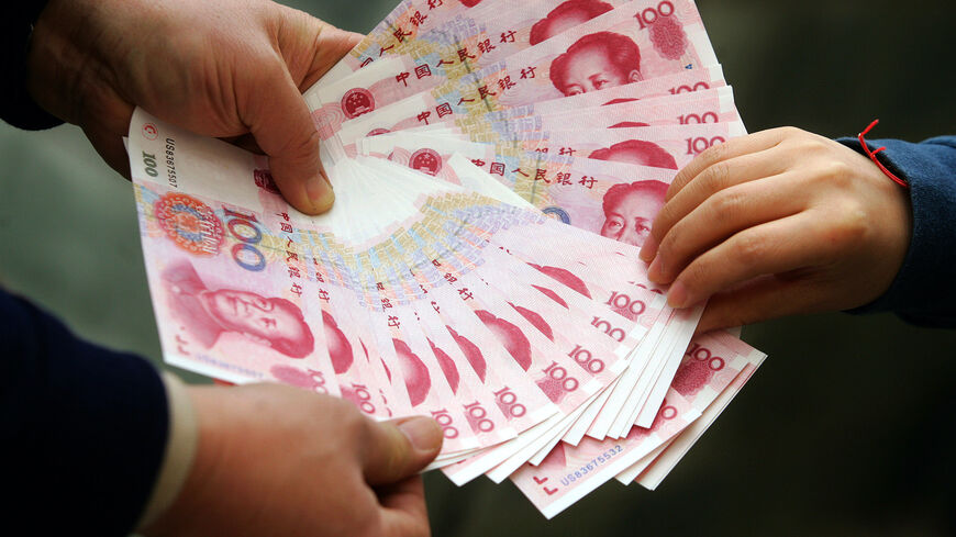 A Chinese vendor displays notes during a cash transaction in Beijing 14 January 2007. The yuan was pegged to the US dollar until 2005 when Beijing decided to revalue it by 2.1 percent and place the unit in a currency basket, allowing a greater but still very tightly controlled margin of flexibility, but the yuan has since slowly but steadily risen in value on the back of China's booming economy and the breaching of the 7.80 level. AFP PHOTO (Photo credit should read STR/AFP via Getty Images)
