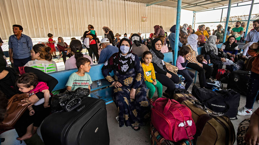 Passengers, who were stranded following the border closure due to the coronavirus pandemic, wait to cross into Iraqi Kurdistan from the Syrian side of the Semalka border crossing in northeast Syria, July 29, 2020.