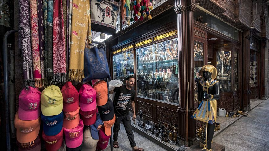 A man walks past a shop selling replicas of Ancient Egyptian statuettes, figurines, and canopic jars at the Khan el-Khalili bazaar area in Egypt's capital Cairo on June 3, 2021. - Pyramids, Tutankhamun masks, Nefertiti busts -- Egypt's souvenir craftspeople are pinning their hopes on a new lease of life, after tourism was battered by the coronavirus pandemic. (Photo by Khaled DESOUKI / AFP) (Photo by KHALED DESOUKI/AFP via Getty Images)