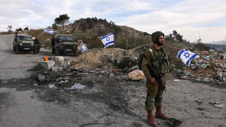 Israeli soldiers guard the road leading to the Homesh Yeshiva (religious school), located at the former settlement of Homesh, west of the West Bank city of Nablus, on December 30, 2021. 