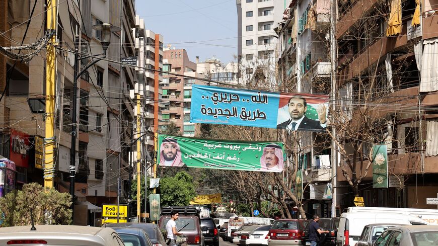 A banner bearing the picture of former Lebanese premier Saad Hariri and a slogan in Arabic which reads "Allah, Hariri, Tariq al-Jdideh" and another depicting Saudi Arabia's King Salman (R) and his son Crown Prince Mohammed with a slogan "Beirut remains Arab despite the haters", hang on a street in the Tariq al-Jdideh neighbourhood of the capital Beirut, on April 27, 2022. - Lebanon's Sunni Muslim community is gearing up for May 15's parliamentary polls without strong leadership for the first time in decades