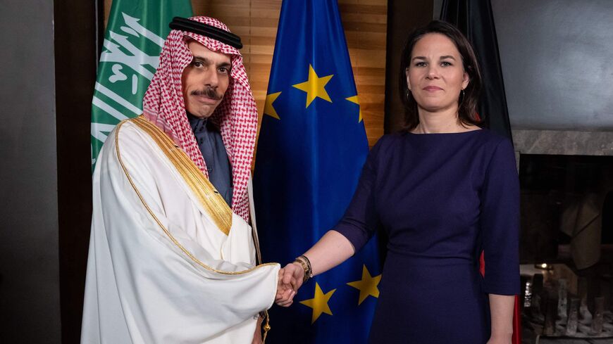 Saudi Arabia's Foreign Minister Faisal bin Farhan Al Saud (L) shakes hands with German Foreign Minister Annalena Baerbock.