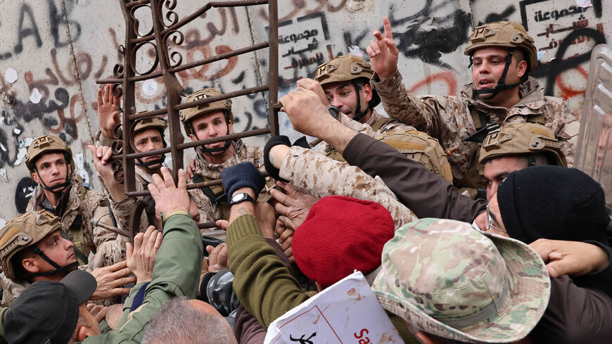 Retired servicemen clash with soldiers outside Lebanon's central bank during a demonstration demanding inflation adjustments to their pensions, Beirut, Lebanon, March 30, 2023.