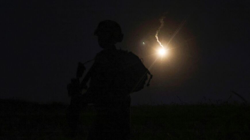 The silhouette of an Israeli soldier is outlined in the sky by a flare fired to search for a rocket that landed near Kibbutz Meitsar in the Israeli annexed Golan Heights, April 9, 2023. - Israel launched artillery strikes on Syria early morning on April 8 after several rockets were fired from there and landed in the Israeli-occupied Golan Heights. Israel's retaliatory strike to rocket attacks from Syria -- which no one has claimed -- is the latest episode in escalating violence in the region. (Photo by JALA