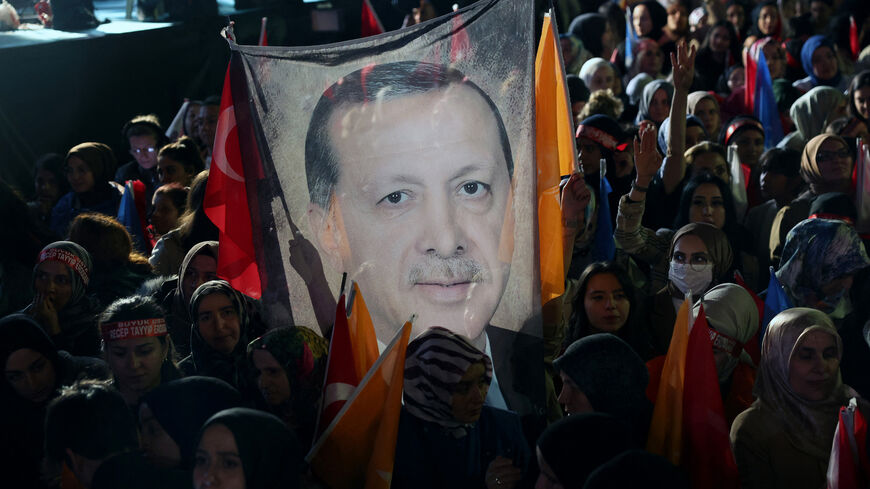 Supporters of Turkish President Tayyip Erdogan hold a flag of his portrait outside the AKP headquarters.