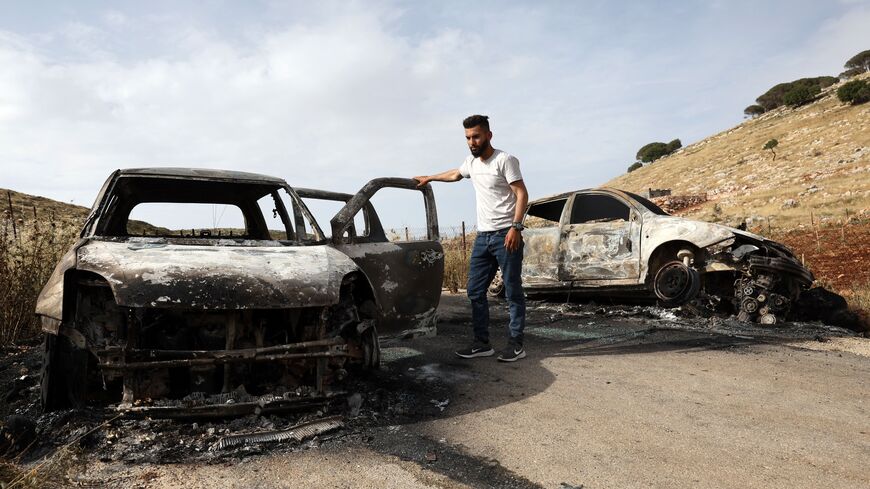A Palestinian man inspects cars, reportedly burnt by Israeli settlers, in the village of Al-Mughayer, east of the occupied West Bank city of Ramallah on May 26, 2023. (Photo by AHMAD GHARABLI / AFP) (Photo by AHMAD GHARABLI/AFP via Getty Images)