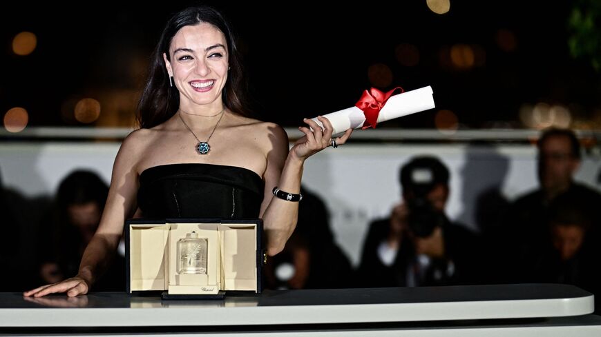 Turkish actress Merve Dizdar poses during a photocall after she won the Best Actress Prize for her part in the film "Kuru Otlar Ustune" (About Dry Grasses) during the closing ceremony of the 76th edition of the Cannes Film Festival in Cannes, southern France, on May 27, 2023. 
