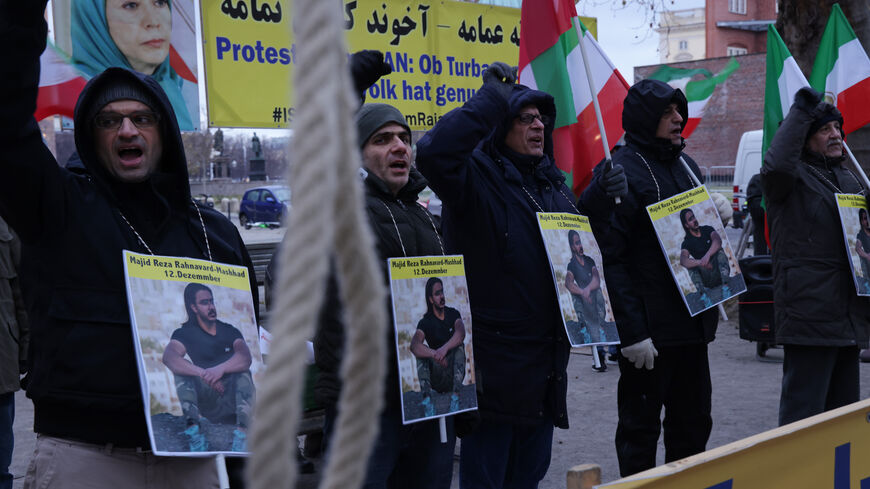Protesters chant slogans next to a hangman's noose as they wear a photograph of Majid Reza Rahnavard, 23, during a demonstration by supporters of the National Council of Resistance of Iran outside the German Foreign Ministry on December 12, 2022 in Berlin, Germany. Iranian authorities said Rahnavard was executed by hanging earlier today as punishment for killing two Iranian security members during recent street riots. Popular protests have been ongoing in Iran since the September death of Mahsa Amini. (Phot