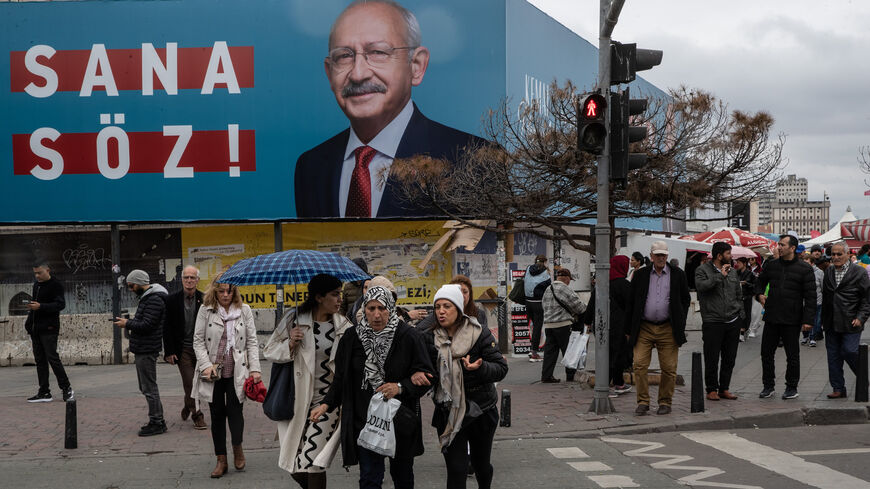 People walk past a poster showing the portrait of Kemal Kilicdaroglu, presidential candidate of the main opposition alliance, and the words translating to "Promise to You," Istanbul, Turkey, May 05, 2023.