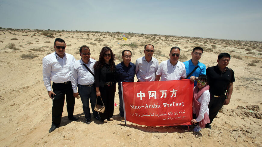 Chinese investors pose for a picture in the land where an industrial city, including an oil refinery, is due to be built following an economic agreement, in the port town of Duqm on May 24, 2016 . Chinese investors signed a deal with Oman's government to establish an industrial city, including an oil refinery, in the port town of Duqm, both sides said in a joint statement. The agreement signed during the ceremony in Muscat would open way for investments worth $10.7 billion by 2022 to finance industrial proj