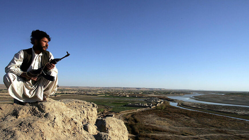 An Afghani policeman looks out to the horizon while on patrol in the mountains surrounding the Helmand River valley in Afghanistan on Feb. 24, 2006.