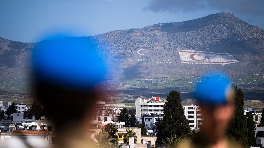 UN peacekeepers in the buffer zone in the divided capital of Nicosia. In the distance, the flag of the self-proclaimed Turkish Republic of Northern Cyprus is seen on the island's northern Kyrenia mountain range