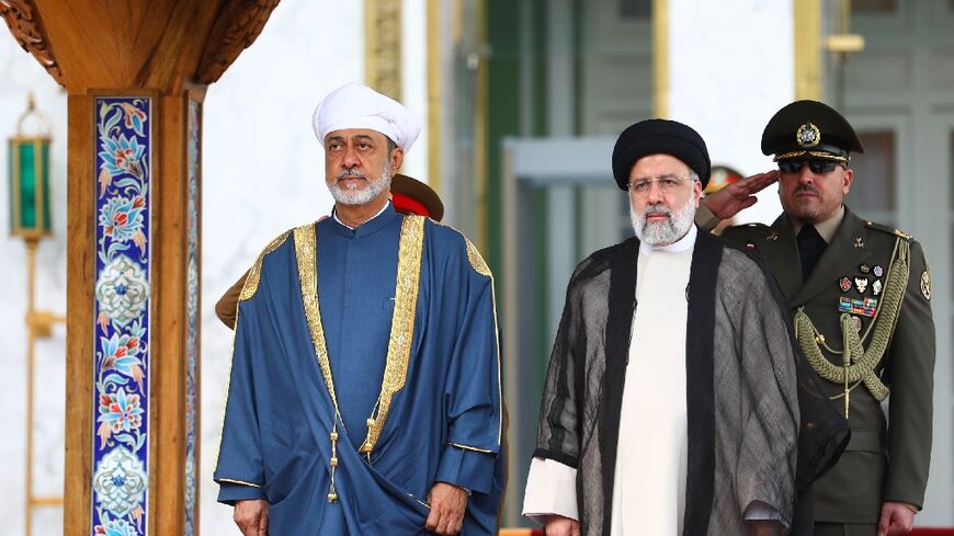 Iran's President Ebrahim Raisi (R) welcomes the Sultan of Oman to Tehran