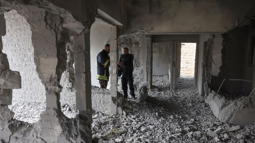 Palestinian police inspect the damage to the West Bank apartment of Islam Faroukh, after Israeli troops demolished it following his indictment for twin bombings at Jerusalem bus stops that killed two Israelis last November