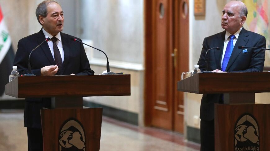 Iraqi Foreign Minister Fuad Hussein, on the right, and his Syrian counterpart Faisal Mekdad hold a press conference in Baghdad on June 4, 2023