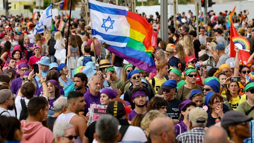 People march with rainbow and Israeli flags during the annual Pride Parade in Tel Aviv