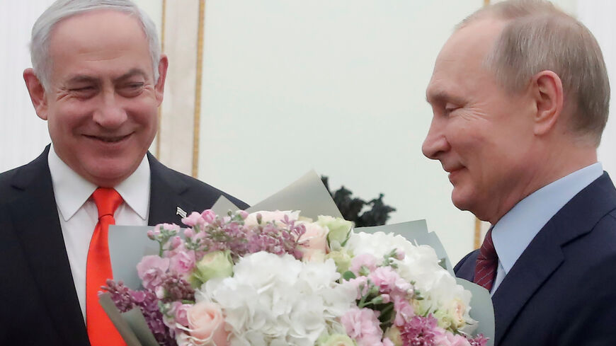 Russian President Vladimir Putin holds flowers next to Israeli Prime Minister Benjamin Netanyahu as they meet at the Kremlin in Moscow on January 30, 2020. (Photo by MAXIM SHEMETOV / POOL / AFP) (Photo by MAXIM SHEMETOV/POOL/AFP via Getty Images)